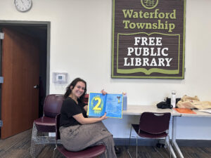 Clinician holding a book at the Waterford Township Free Public Library