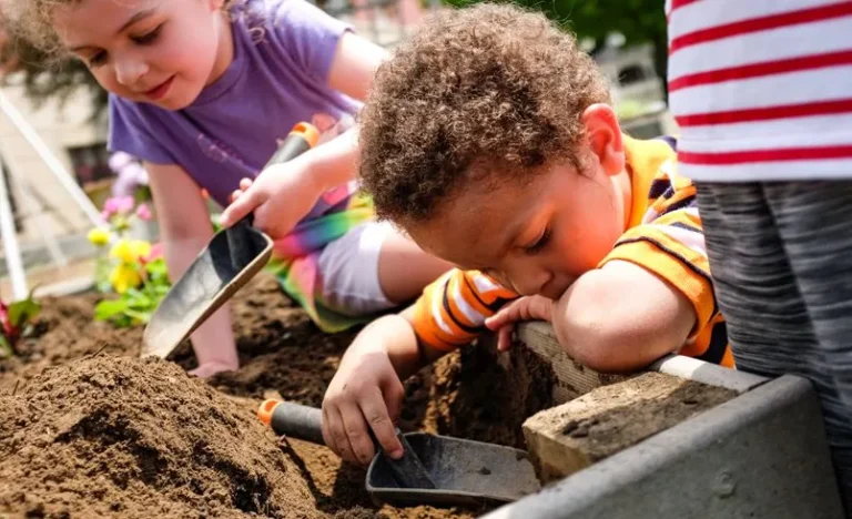 Children digging in soil with garden trowels